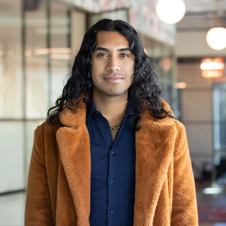 Man in a brown fur coat indoors