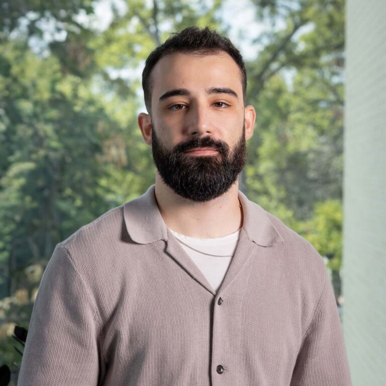 Man with beard against forest backdrop in casual attire