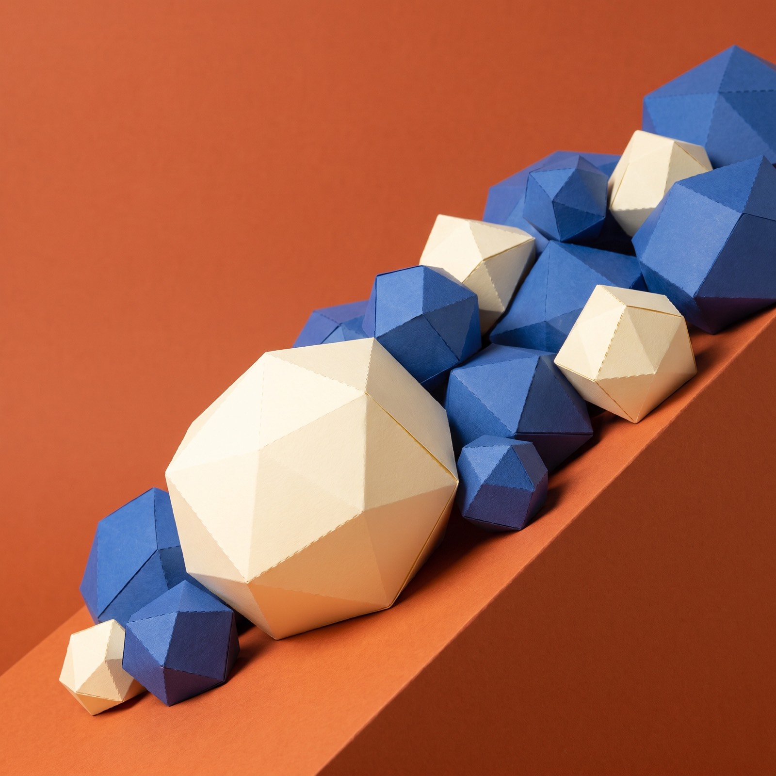 Paper sculpture of a landslide of boulders tumbling down a slope