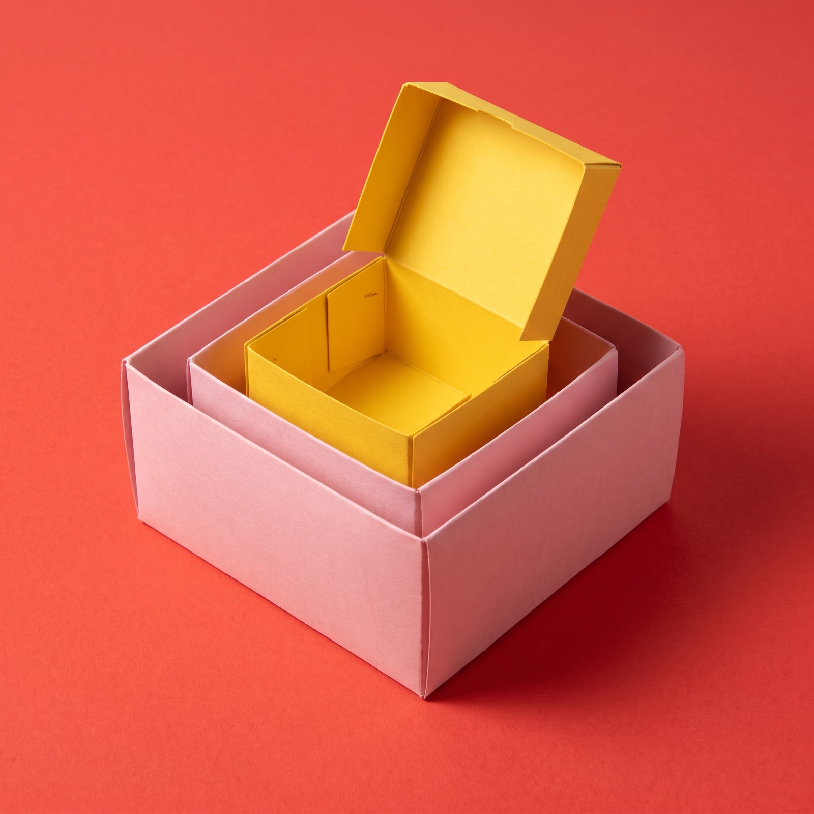 Paper sculpture of a set of boxes nested one inside another, the innermost one open