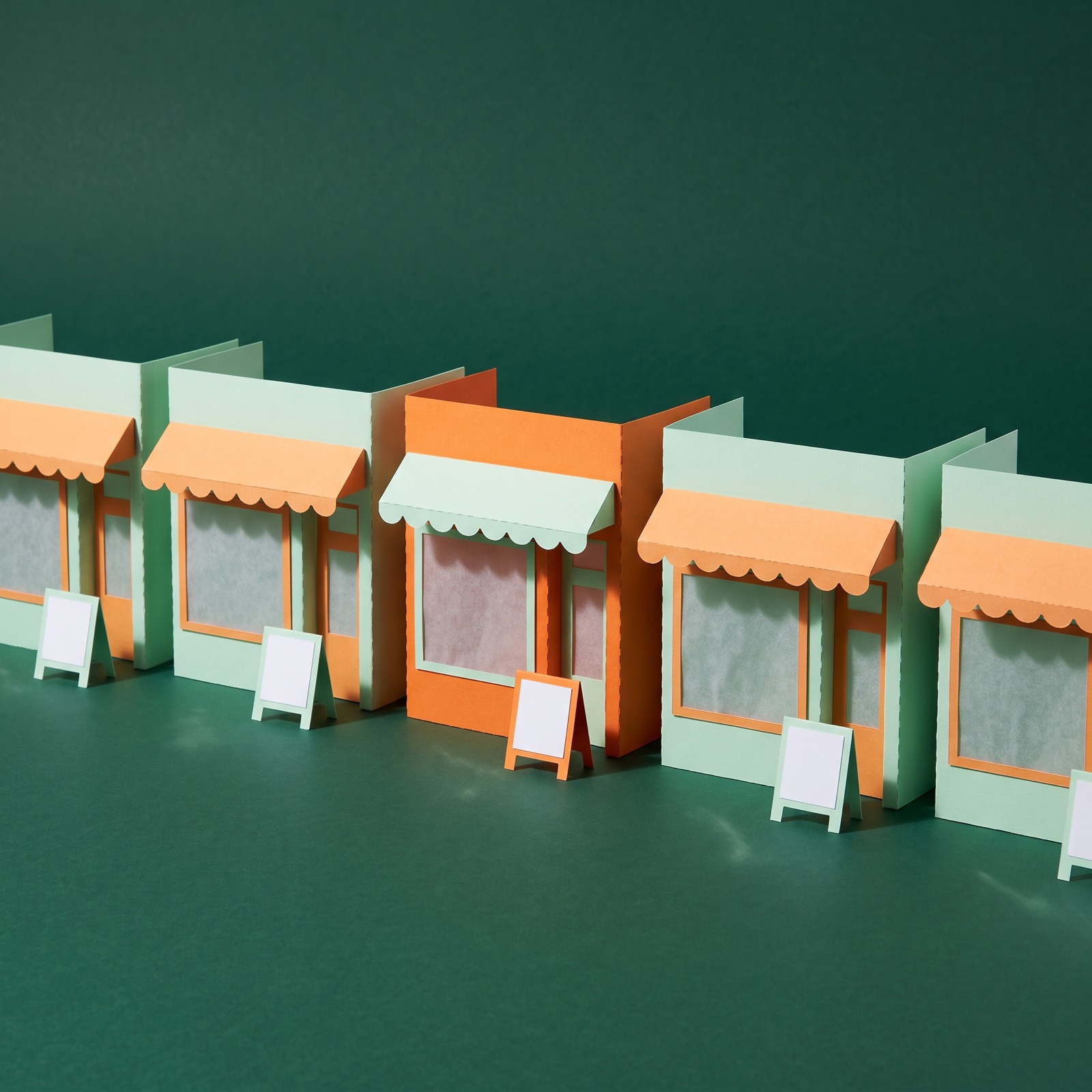 Paper sculpture of a row of identical small shopfronts