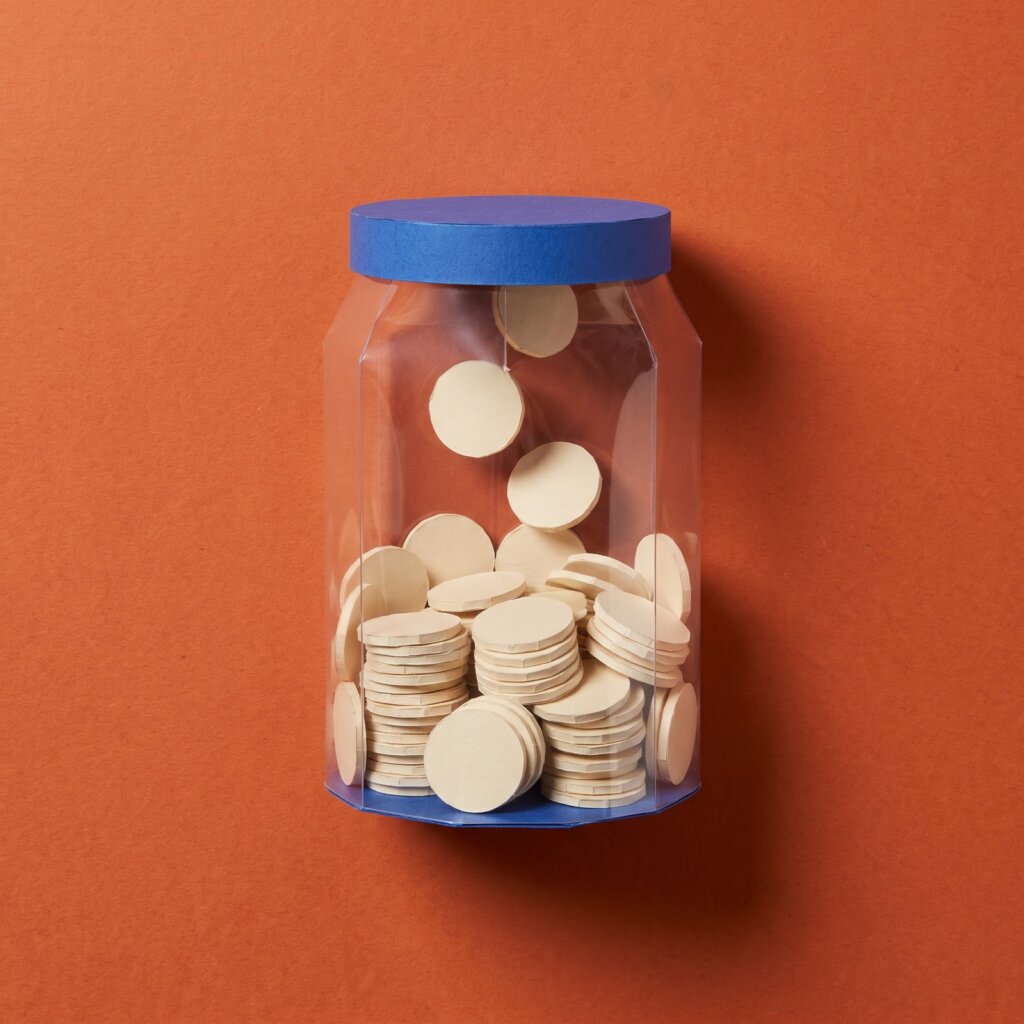 Paper sculpture of a glass jar filling up with many coins