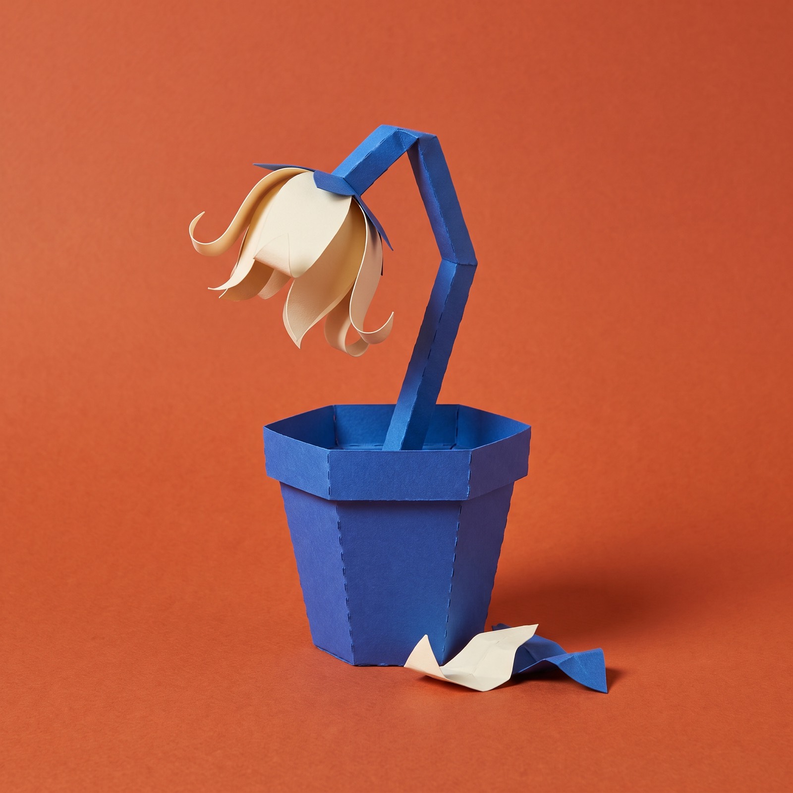 Paper sculpture of a wilting flower in a pot