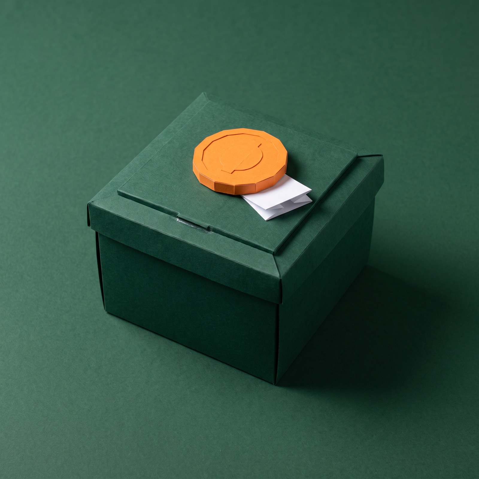 A closed metal strongbox with a single coin resting on its lid.